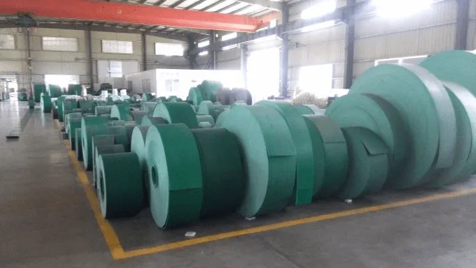 Rollos de banda elevadora industrial almacenados en fábrica