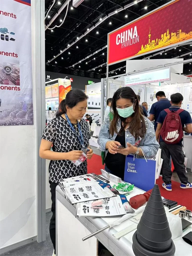 Clientes reunidos en el stand de YT Conveyor consultando soluciones de transportadores de tornillo