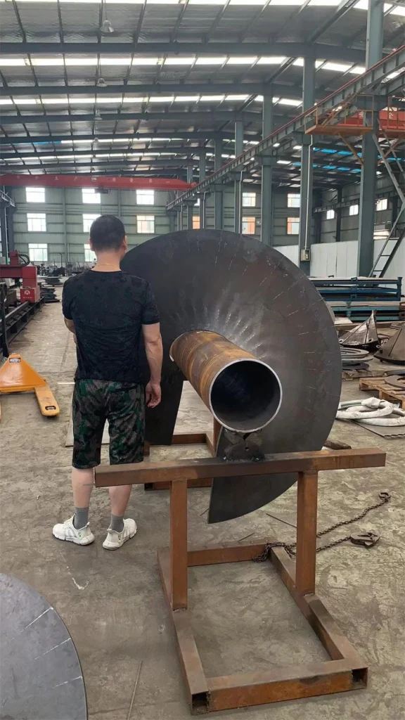 Hélice helicoidal gigante de acero inoxidable para transportador de tornillo industrial en taller de fabricación